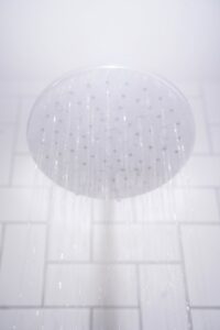 water from round gray stainless steel shower head