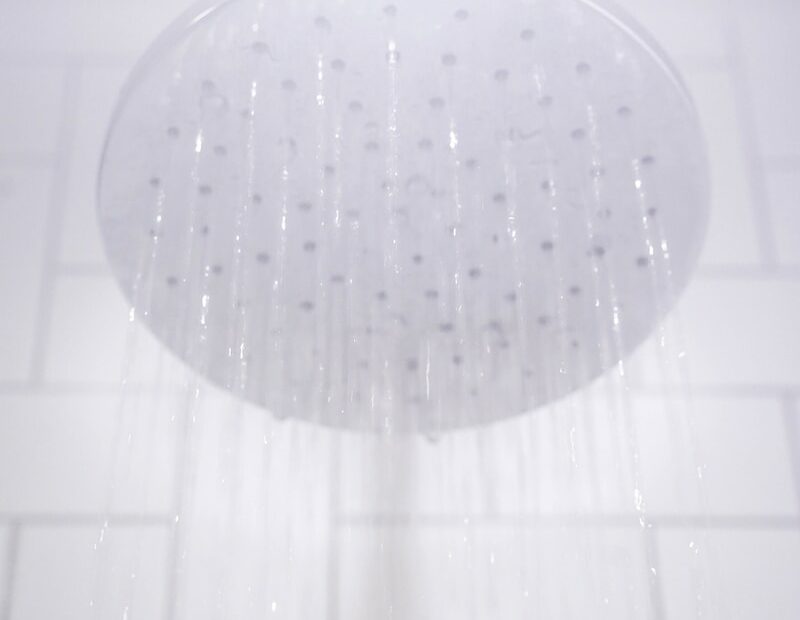 water from round gray stainless steel shower head